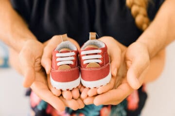 Dziecięce buty w rękach pary rodziców